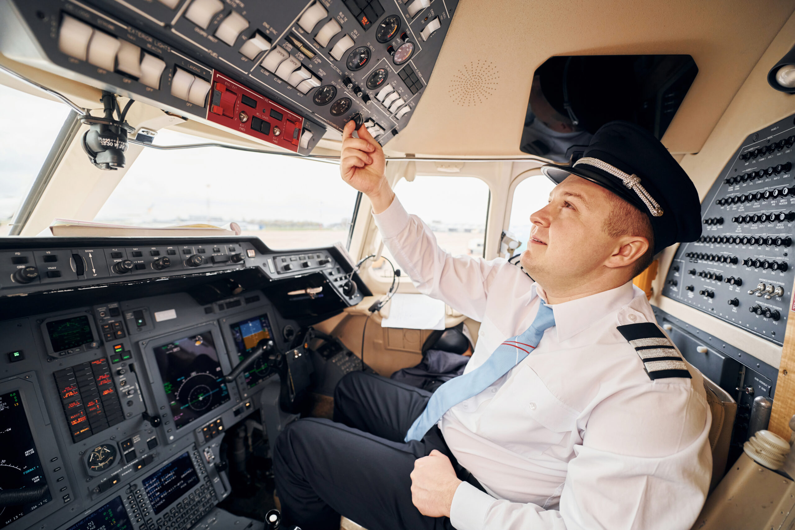 Professional worker. Pilot in formal wear sits in the cockpit and controls airplane.